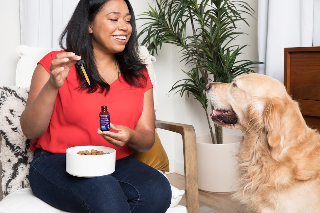 children support animals — woman in red tank top and black pants sitting on brown wooden chair holding white ceramic